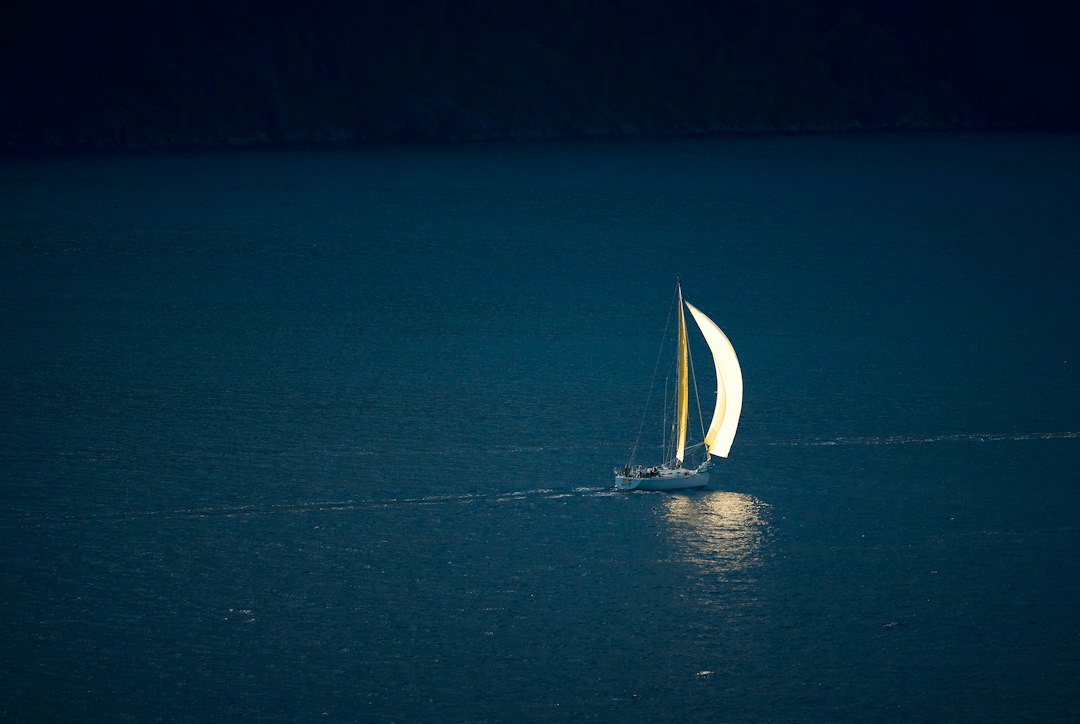 Sailboat navigating under a dark night sky