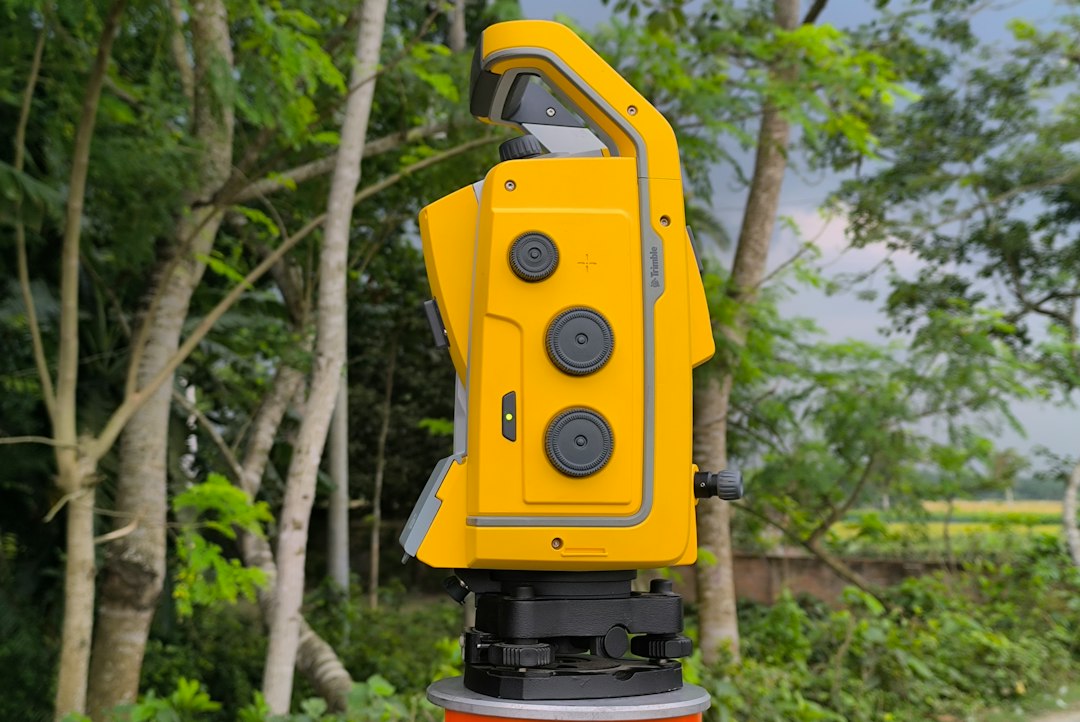 Modern robotic total station mounted on a tripod at a survey site